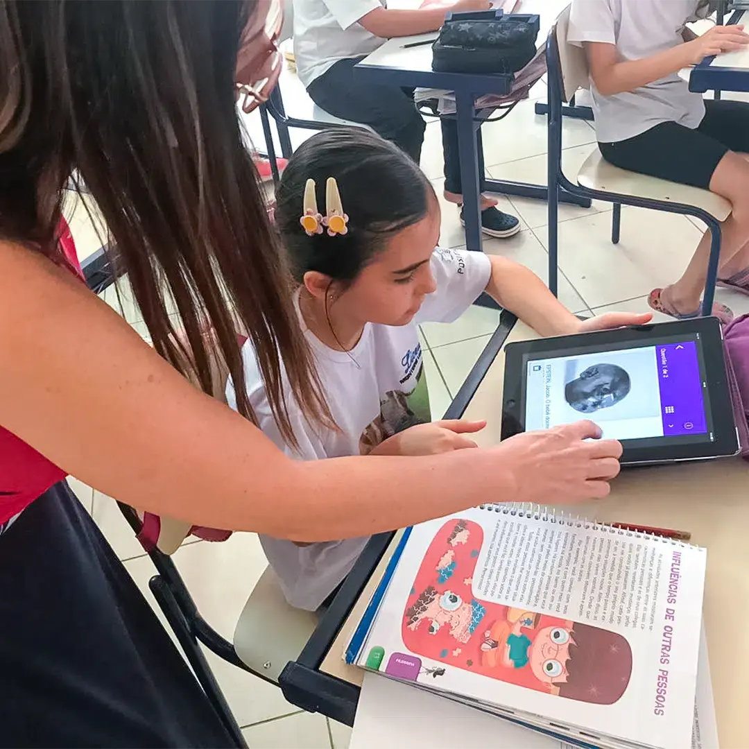 Aluna sendo conduzida por professora em sala de aula