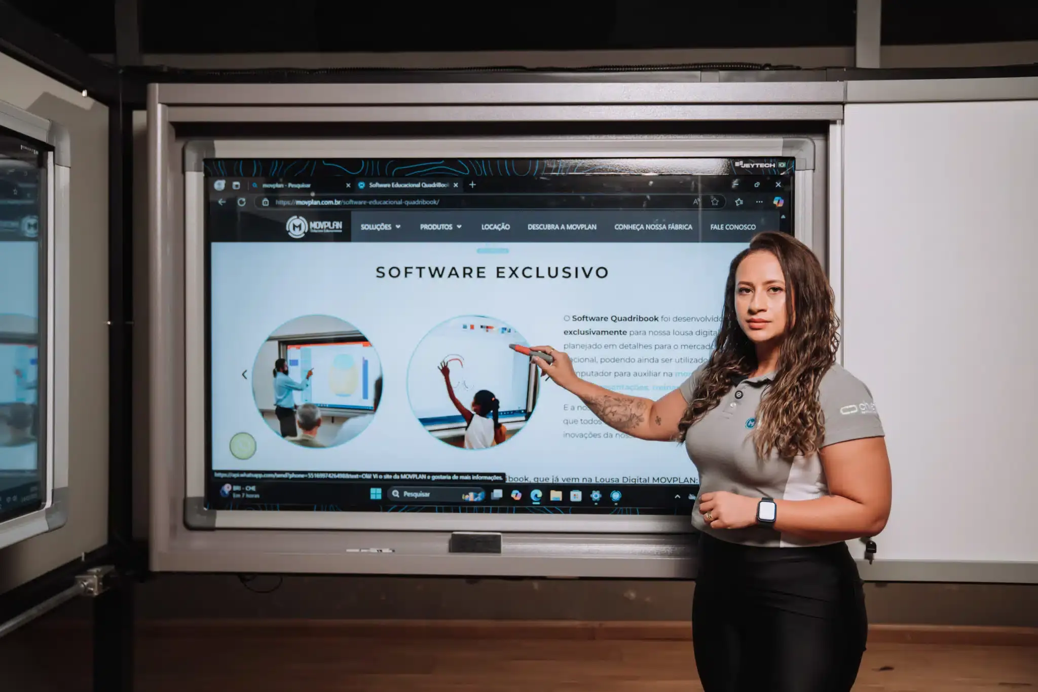 Educadora apontando para lousa digital na sala de aula